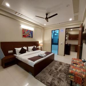 古尔冈The Lodgers 2 BHK Serviced Apartment infront of Artemis Hospital Gurgaon的一间卧室配有一张床和吊扇
