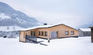 梅劳Ferienhaus Schihütte Mellau的山底下雪中的房子