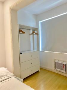里约热内卢Apartamento Encantador Leme - Prédio na Orla的一间卧室配有一张床、梳妆台和镜子