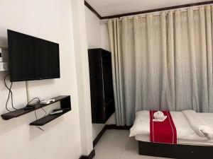 琅勃拉邦Jasmine Place House的一间卧室配有一张床和一台平面电视