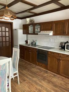 伊泽拉河畔亚布洛内茨Penzion Breuer的厨房配有木制橱柜和炉灶烤箱。