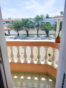 萨尔瓦多Maré Hostel Itapuã的享有海滩和棕榈树景致的阳台