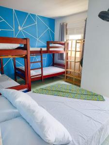 萨尔瓦多Maré Hostel Itapuã的一间卧室设有两张双层床和蓝色的墙壁
