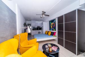法纳贝海滩1013 studio Garden City的客厅配有黄色的沙发和桌子