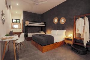 巴卡拉尔Che Bacalar Hostel & Bar Adults Only的一间卧室配有一张床、一张桌子和一张床