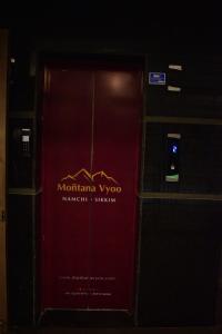NamchiHOTEL MONTANA VYOO的红色的门,上面有标志