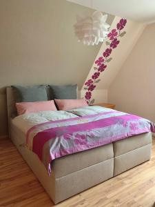 索尔陶Ferienwohnung Paulita的一间卧室配有一张带粉色和紫色床单的床