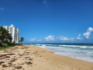 圣胡安Enjoy our Luxurious Penthouse in Condado!的拥有建筑和海洋的海滩
