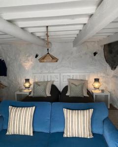 Fajã de São JoãoCasa Tosca的客厅里一张蓝色的沙发,配有两盏灯