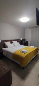 尼姆SQUARE HOTEL的一间卧室配有一张带黄色毯子的大床