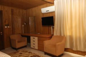 Kahta内姆鲁特科马吉酒店的一间卧室配有书桌、电视和两把椅子
