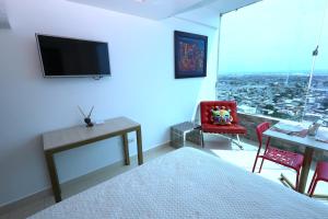 萨利纳斯Mejor que un Hotel的一间卧室配有一张床、一张书桌和一台电视