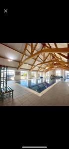 BarePark Dean Morcambe的一座带游泳池和木制天花板的大型建筑