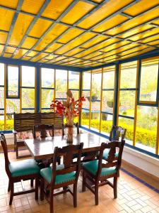 萨兰托El Rancho de Salento的一间带桌椅和窗户的用餐室