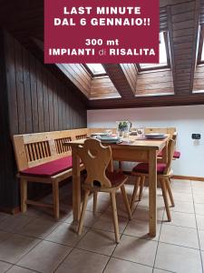 阿尔巴迪卡纳泽伊MANSARDA MARMOLADA sui campi da sci的一间带木桌和椅子的用餐室