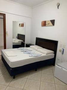 瓜鲁雅伯南布哥太阳酒店的一间卧室配有一张带镜子的大床