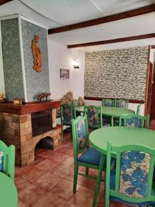 波罗维茨Villa Sveti Dimitar的一间设有壁炉和绿色桌椅的用餐室