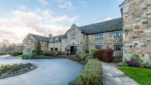 巴恩斯利Mercure Barnsley Tankersley Manor Hotel的享有带车道的大型石屋外景