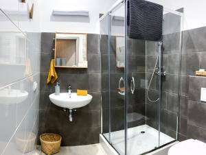 索波特Chummy House Sopot的一间带玻璃淋浴和水槽的浴室