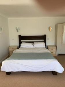 圣艾夫斯Treloyhan Lodge的一间卧室设有一张大床和两个床头柜