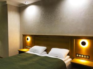 沙安Molfar Resort Hotel & SPA的一间卧室配有带两个枕头的绿色床