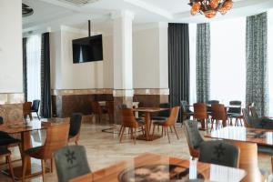 沙安Molfar Resort Hotel & SPA的餐厅设有桌椅和平面电视。