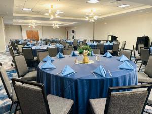 迈尔斯堡Crowne Plaza Ft Myers Gulf Coast, an IHG Hotel的配有一张带蓝色餐巾和椅子的桌子的房间