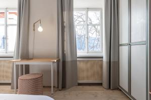 卡尔达罗Smart Suites Kaltern - Apartments am Kalterer See的一间卧室设有书桌和窗户。