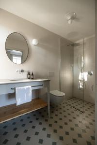 卡尔达罗Smart Suites Kaltern - Apartments am Kalterer See的一间带水槽、卫生间和镜子的浴室