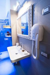 罗马多莫斯芬提斯酒店的浴室设有白色水槽和镜子