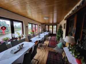 巴特黑雷纳尔布Hotel Schönblick的餐厅设有长桌子、椅子和窗户。