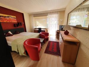 巴特黑雷纳尔布Hotel Schönblick的卧室配有一张床、一张桌子和椅子