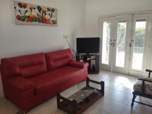 圣达菲苏豪临时公寓的客厅配有红色沙发和电视