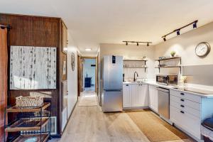 West RutlandVermont Meadow House的厨房配有白色橱柜和不锈钢冰箱