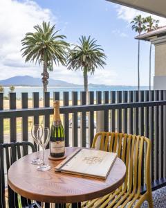 伯马吉Bermagui Beach Hotel的阳台上的桌子上摆放着一瓶葡萄酒