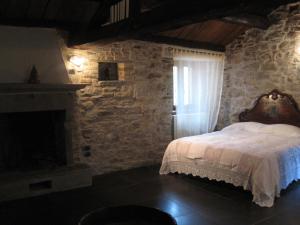 阿尼奥内洛坎达拉坎帕娜酒店的一间卧室设有一张床和石墙