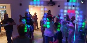 德兹维济诺RIWIERA Dźwirzyno的一群人在一间有彩灯的房间跳舞