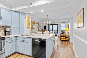 大西洋滩Dunescape Villas 211的厨房配有白色橱柜和黑色洗碗机