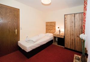 萨尔巴赫全景兰德酒店的一间小卧室,配有一张床和一张书桌