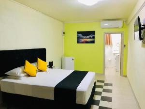 阿皮亚Moatoga Hotel的一间卧室配有一张带黄色和黑色枕头的床