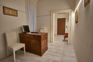 博洛尼亚Cuore di Bologna Suites的走廊设有一张桌子、一台电视和一把椅子