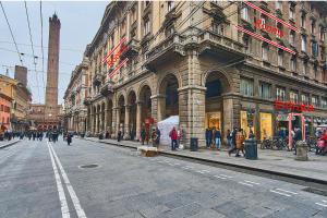 博洛尼亚Cuore di Bologna Suites的一条城市街道,人们在大楼前走