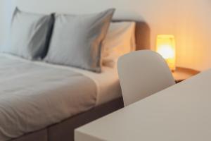里斯本Elegant 3 bedroom apt - City centre - garage - metro的一张带白色枕头的床和一张带台灯的桌子