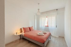 里斯本Elegant 3 bedroom apt - City centre - garage - metro的一间卧室配有带橙色床单的床和窗户。
