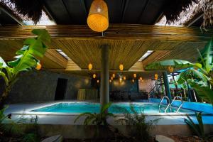 峰牙Phong Nha Memory Homestay的一座大型游泳池,位于一座拥有坐式浴盆的建筑中