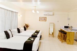 阿皮亚Moatoga Hotel的酒店客房带两张床和厨房