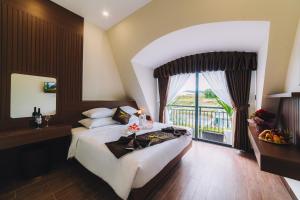大叻GREENECO DA LAT HOTEL - Khách sạn Green Eco Đà Lạt的一间卧室设有一张大床和一个大窗户