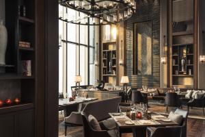 天津天津四季酒店的餐厅设有桌椅和大窗户。