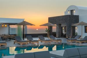 卡特瑞杜斯Onyx Hotel & Suites的一个带躺椅和日落的度假游泳池