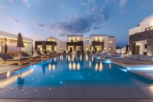 卡特瑞杜斯Onyx Hotel & Suites的带沙发的大型游泳池和大楼